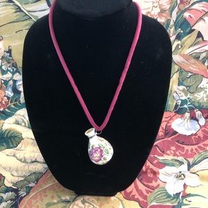 Porcelain perfume bottle on silk cord.